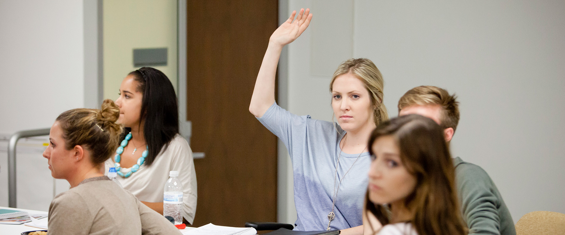 A student raising her hand in class
