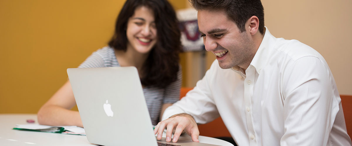 Two students working on an assignment on a laptop