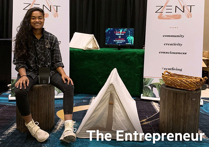 A student next to their project at an event with the words The Entrepreneur